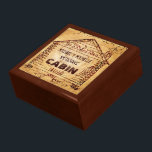 Log Cabin Personlig Faux Wood Smyckeskrin<br><div class="desc">Den här anpassningsbarna kabinkonstruktionen har ett snurrande, faux wood-utseende som blir lättare i mitten. Inuti den gammaldags kabinen teckning - härledd från en vintage, reklamen från tidigt 1900 - kan du lägga till ditt namn. Ord kan också bytas ut mot "HEM" eller "kort ord". Utformningen görs i skuggor av beige,...</div>