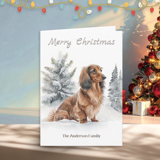 Long-hårad Dachshund Sause Hund God jul Helgkort (A Christmas card with illustration of a long-haired dachshund "sausage dog" with pine trees in snow)