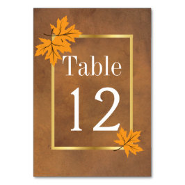 löv av orange på brunt bordsnummer i bröllop