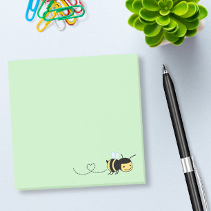 Lyckligt bi som omkring surrar på grönt post-it block