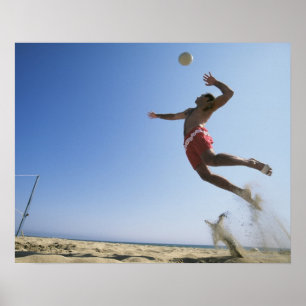 Male strandvolleybollspelare som upp till hoppar poster