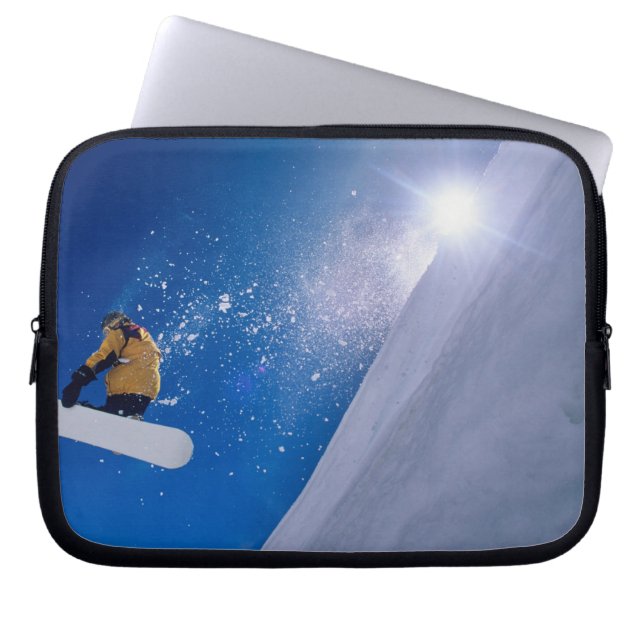 Man flyger genom luften på en snowboard med laptop fodral (Framsidan)