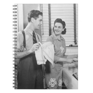 Man och kvinna som gör disk anteckningsbok med spiral