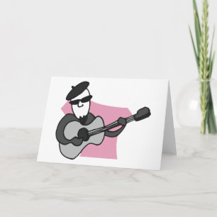 Man som bär beret spelar akustisk gitarr kort