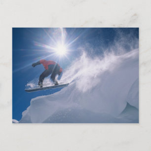 Man som hoppar från en stor avsats på en snowboard vykort