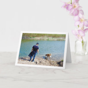 Man vid flod med hund kort