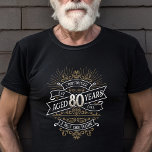 Manar Funny Whiskey 80:e födelsedagen T Shirt<br><div class="desc">Fira de stora 8-0 med stil och humor med den här vintagen whiskyinspirerade födelsedagsdesignen. Den svarta, guld och vita typografin är ornat och elegant, ge en klassisk vintage. Perfekt för en man (eller kvinna!) i ditt liv som kärlekar sin soffa, sprit, bourbon och andra spritdrycker. Innehåller en vintage av anpassade...</div>
