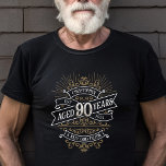 Manar Funny Whiskey 90:e födelsedag T Shirt<br><div class="desc">Fira de stora 9-0 med stil och humor med den här vintagen whiskyinspirerade födelsedagsdesignen. Den svarta, guld och vita typografin är ornat och elegant, ge en klassisk vintage. Perfekt för en man (eller kvinna!) i ditt liv som kärlekar sin soffa, sprit, bourbon och andra spritdrycker. Innehåller en vintage av anpassade...</div>