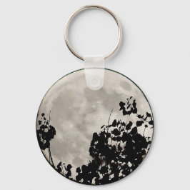 Måne bakom mörka blad nyckelring