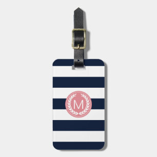 Marinblå rand med den rosa lagrarkranmonogramen bagagebricka