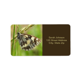 Marmorerad vit fjäril på gräs adressetikett