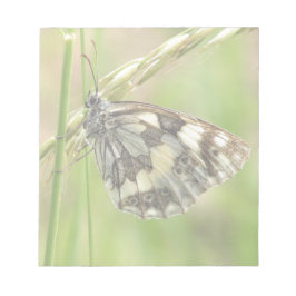 Marmorerad vit fjäril på gräs anteckningsblock