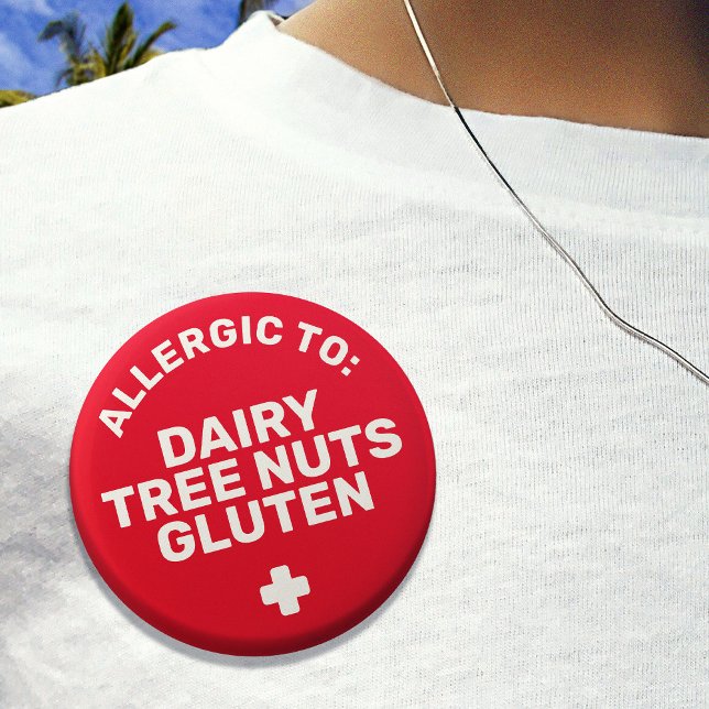 Medicinsk varning vid lätt rödvit livsmedelsallerg knapp (Red badge that says 'allergic to: dairy, tree nuts, gluten')