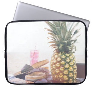 Minimalistisk fotografi av ananas nära sandaler a laptop fodral
