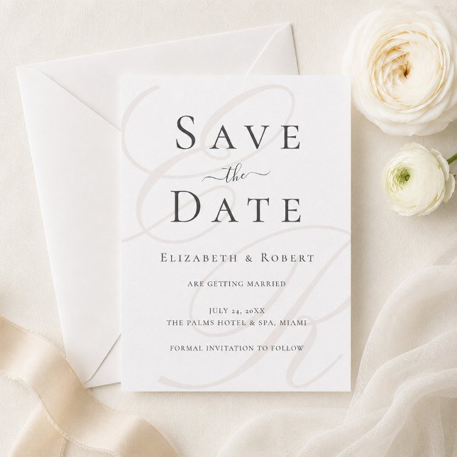 Minimalistisk Monogram Rädda Datum Kort (Minimalist Monogram Save the Date Card on a table with white flowers and a silk ribbon)