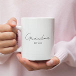Minimalistisk mormor EST 2025 | Personlig Gift Kaffemugg<br><div class="desc">Fira en speciell milstolpe med denna minimalistiska mormor EST 2025 personlig mugg - en perfekt gåva till ett första mormor! Designat med elegantens moderna typografi mot en skarp vit bakgrund är mugg både meningsfullt och snyggt. Anpassa året för att markera hennes nya kapitel och ge för henne en daglig påminnelse...</div>
