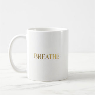Minimalistisk typografi med guldet ordet andas kaffemugg