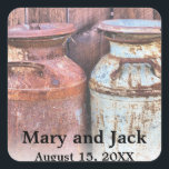 Mjölk Cans Landsbyggsbröllop Rustic Old Farm Budge Fyrkantigt Klistermärke<br><div class="desc">Vintage Metall Jugs Bröllop Rustic land med gamla stil-antika 10 gallon juggar från metall mjölk. Vintagen letar efter din bröllopsfest. Monogram,  text,  brud och groom namn är lätta att byta till kostym efter dina behov. Alla teckningar och bilder ©</div>