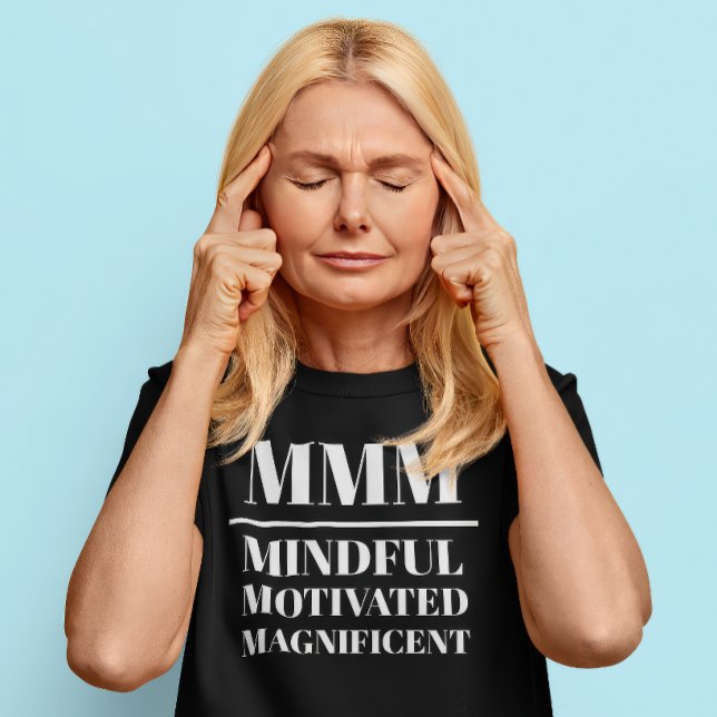 MMM- minutiös, motiverad, magnifik T Shirt (Middle aged Caucasian woman wears a t-shirt that reads "MMM: Mindful, Motivated, Magnificent")