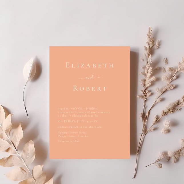 Modern Chic Korallpersika Minimalistisk Skrift Brö Inbjudningar (Modern Chic Coral Peach Minimalist Script Wedding Invitation on a table next to soft pink flowers)