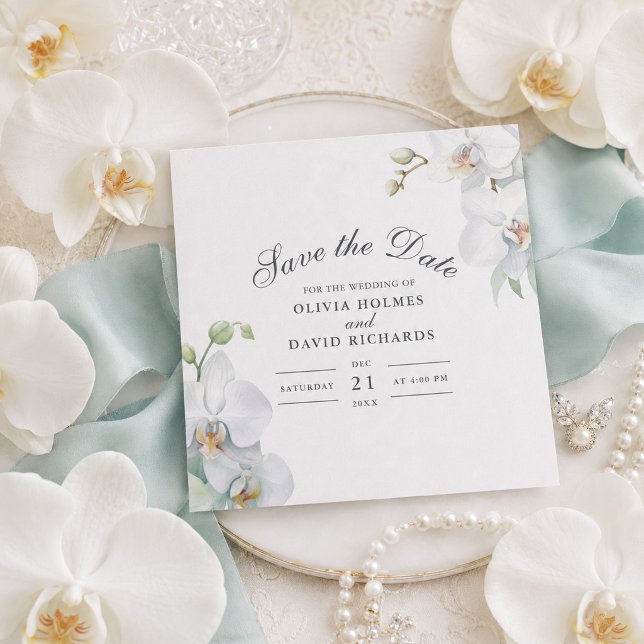 Modern Elegant Vit Orkidé Spara Datum Kort (Modern Elegant White Orchid Save the Date Card on a table with white orchids)