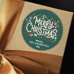 Modern festlig söt grönt och vit God jul Runt Klistermärke<br><div class="desc">Fira helgdagarna i stil med detta moderna klistermärke som har en grönt bakgrund och en glad vit och röd typografi. "God jul"-meddelandet läggs till med holly, snöflingor och baubles och skapar en lekfull men elegant-design. Anpassade med din familj namn och år är det här klistermärket perfekten för att ge helgdagskort,...</div>