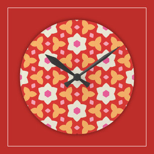 Moderna blommor på röd och persikofärgad geometris rund klocka