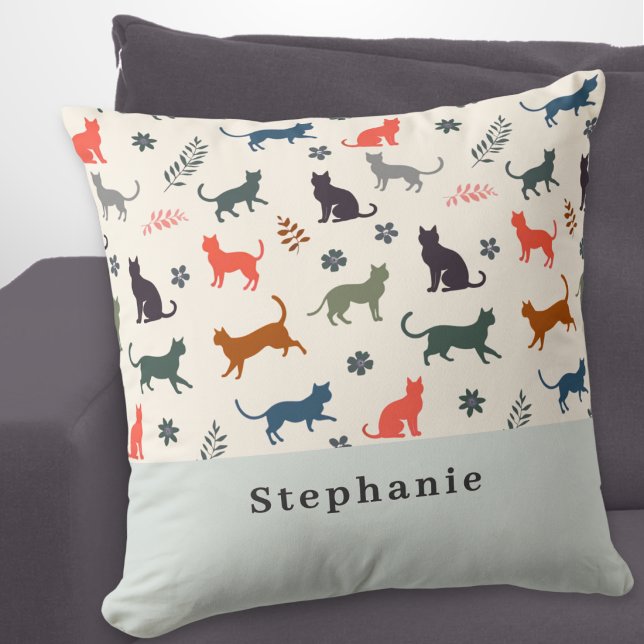 Moderna kattmönster Elegant kräm Personlig Kudde (A stylish, modern pillow with pattern of cat silhouettes in various colors, personalized with a name)