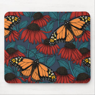 Monarch-fjäril på röda konefloger musmatta