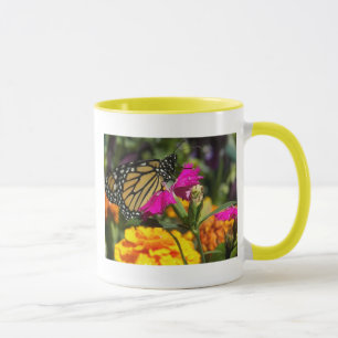 Monarkfjäril på den rosa ringblomma-muggen mugg