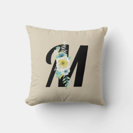 Monogram med blomsterdekoration i akvaton och vitt kudde