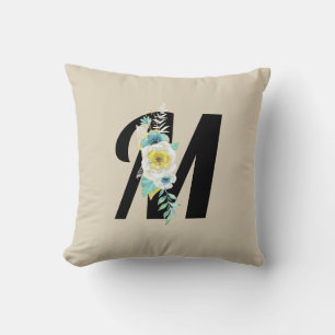 Monogram med blomsterdekoration i akvaton och vitt kudde