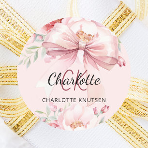 Monogram med rosafärgade blomster och rosett runt klistermärke