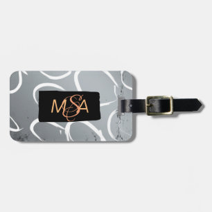 Monogram på svart på silverbotten med vita cirklar bagagebricka