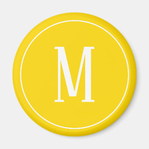Monogramvit på den guld- gula rundamagneten magnet