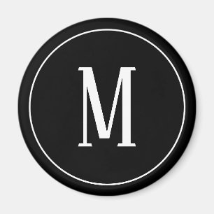 Monogramvit på den svart rundamagneten magnet