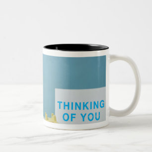 Mopsvalpsitta på säng bredvid telefonen och Två-Tonad mugg