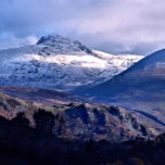 MOUNTAIN-VYER CANVASTRYCK<br><div class="desc">En fotografisk design av snö omfattade toppar i bergsregioner i Wales.</div>