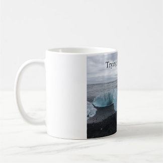 Mugg med is på svart strand