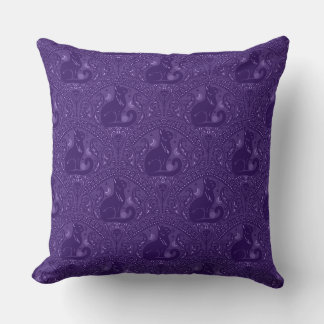 Mystisk svart katt i violett kudde
