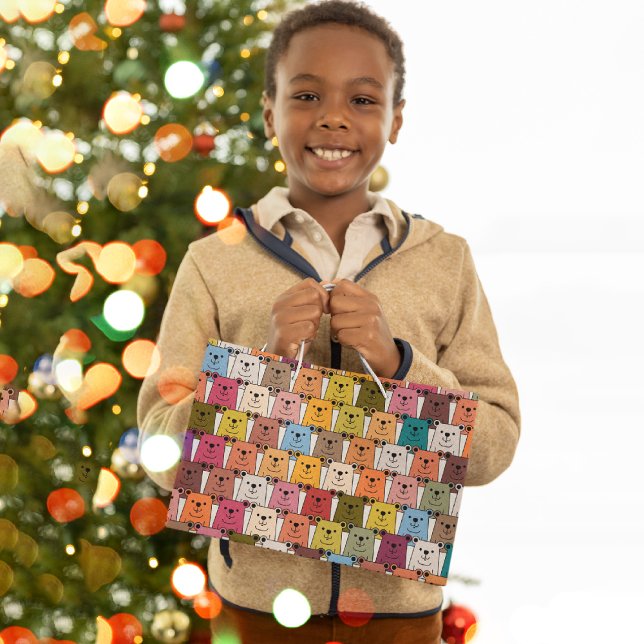 Nalle (smiling kid holding a gift bag in front of a christmas tree)