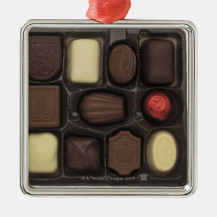 närbild av en boxas av blandade choklader julgransprydnad metall