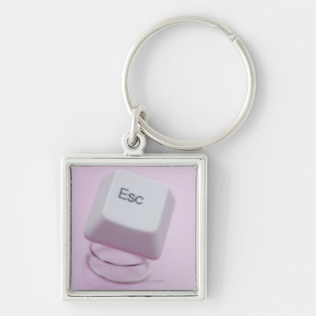 Närbild av en flyktnyckel fyrkantig silverfärgad nyckelring (Framsidan)