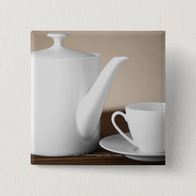 Närbild av en kopp och en saucer med en teakettle knapp (Framsida)