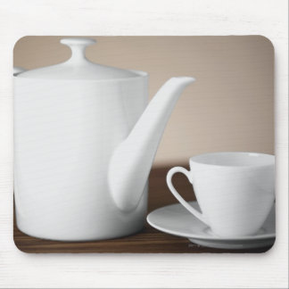 Närbild av en kopp och en saucer med en teakettle musmatta
