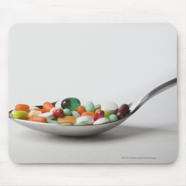 Närbild av pills i en sked musmatta (Framsidan)