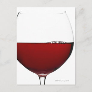 Närbild på glas med rött vin på vit yta vykort
