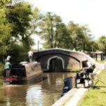 NARROWBOATS CANVASTRYCK<br><div class="desc">En konstkonstruktion av en smalbåt som närmar sig ett lås och en man som fiskar. Kanalbåtar, som i Förenade kungariket kallas smalbåtar, användes ursprungligen för att transportera varor runt land. De används nu främst för fritid och lockar människor från hela världen att njuta av vår landsbygd. Dessa båtar ser mycket...</div>