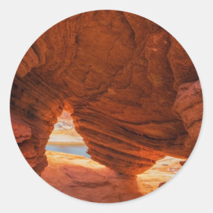 Naturskön eroderad sandstensgrotta runt klistermärke
