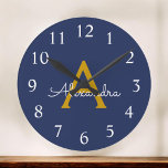 Navy Blue Guld Modern Script Girly Monogram Namn Rund Klocka<br><div class="desc">Namn Clock för marinblått och Guld Simple Script Monogram. Det gör perfekten söt 16-årsdag,  bröllop,  möhippa,  årsdag,  barndusch eller filmfest för någon som kärlek glam lyx och chic stilar.</div>